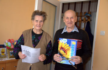 Zdjęcie główne przedstawia parę seniorów uczestniczących w projekcie pod nazwą Centrum Aktywności Seniora